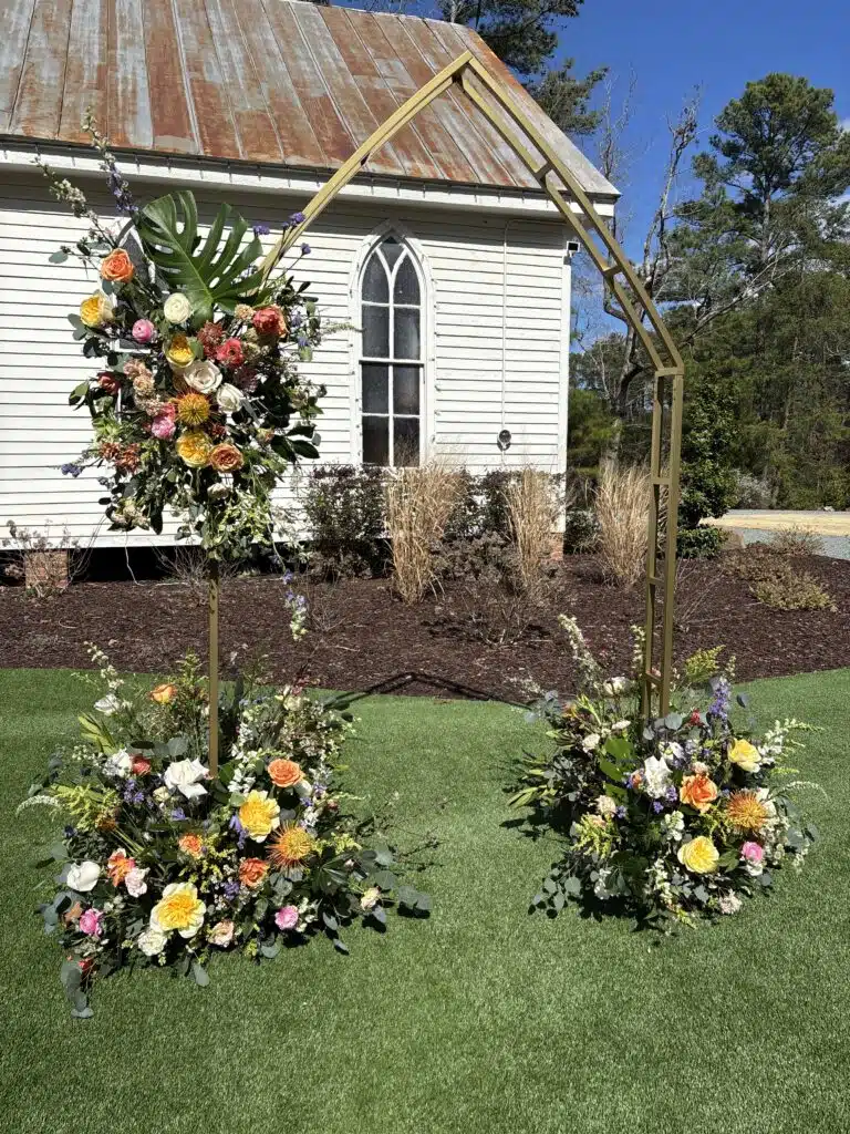 Floral wedding arch with autumn blooms set up in front of O'Kelly Chapel