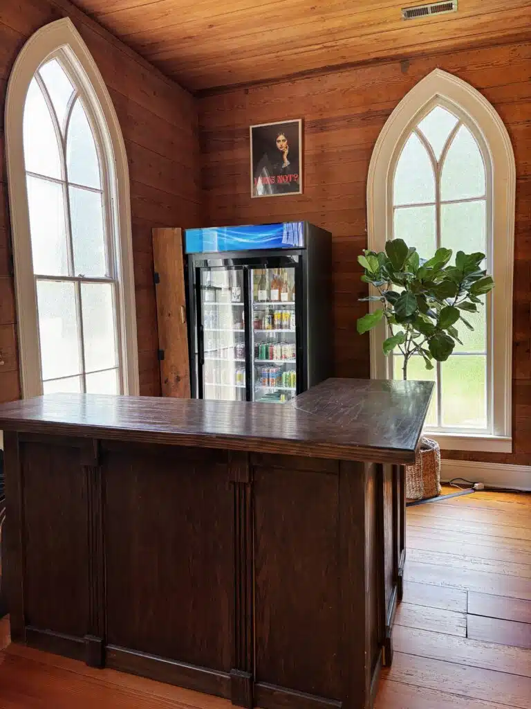 Bar area framed by Gothic arched windows inside O'Kelly Chapel